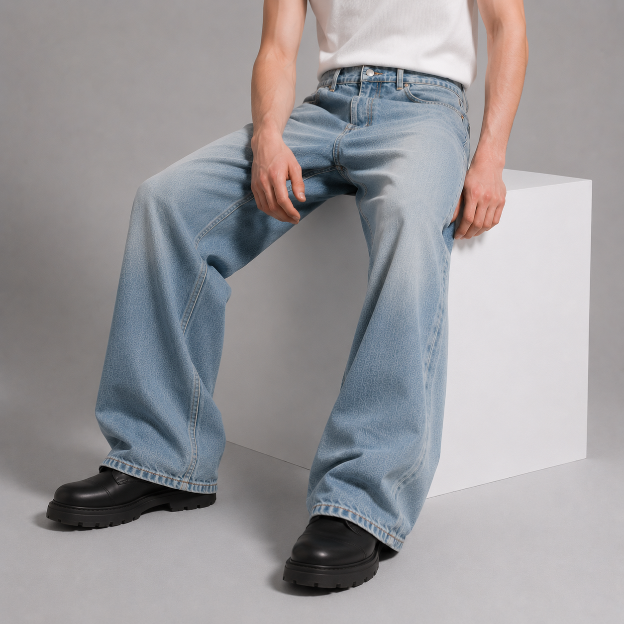 Person wearing blue jeans and black shoes on a gray background