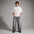 Person wearing a white t-shirt and gray jeans against a plain background