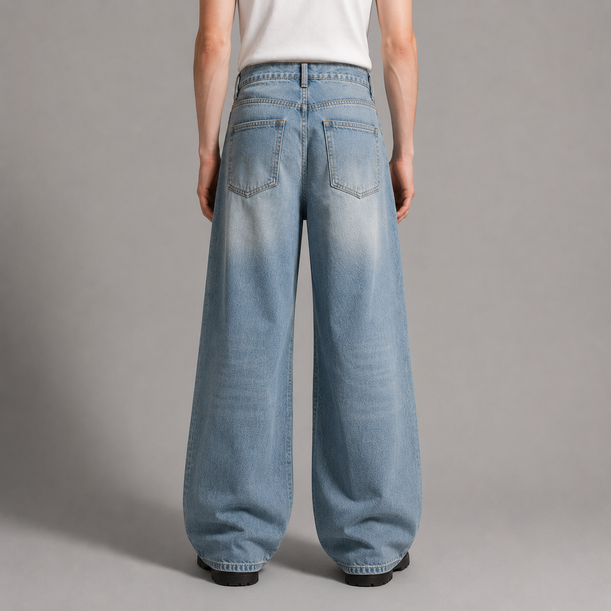 Person wearing light blue wide-leg jeans on a gray background