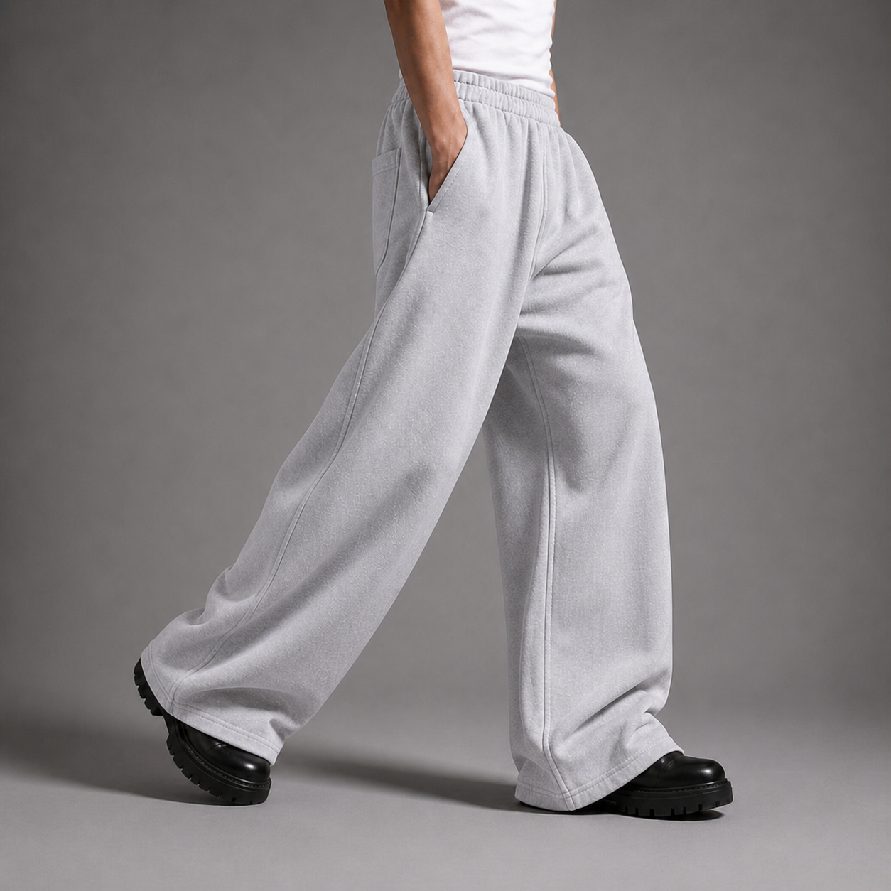 Person wearing light gray sweatpants on a gray background

شخص يرتدي بنطالًا رياضيًا رماديًا فاتحًا وحذاءً أسود على خلفية رمادية.