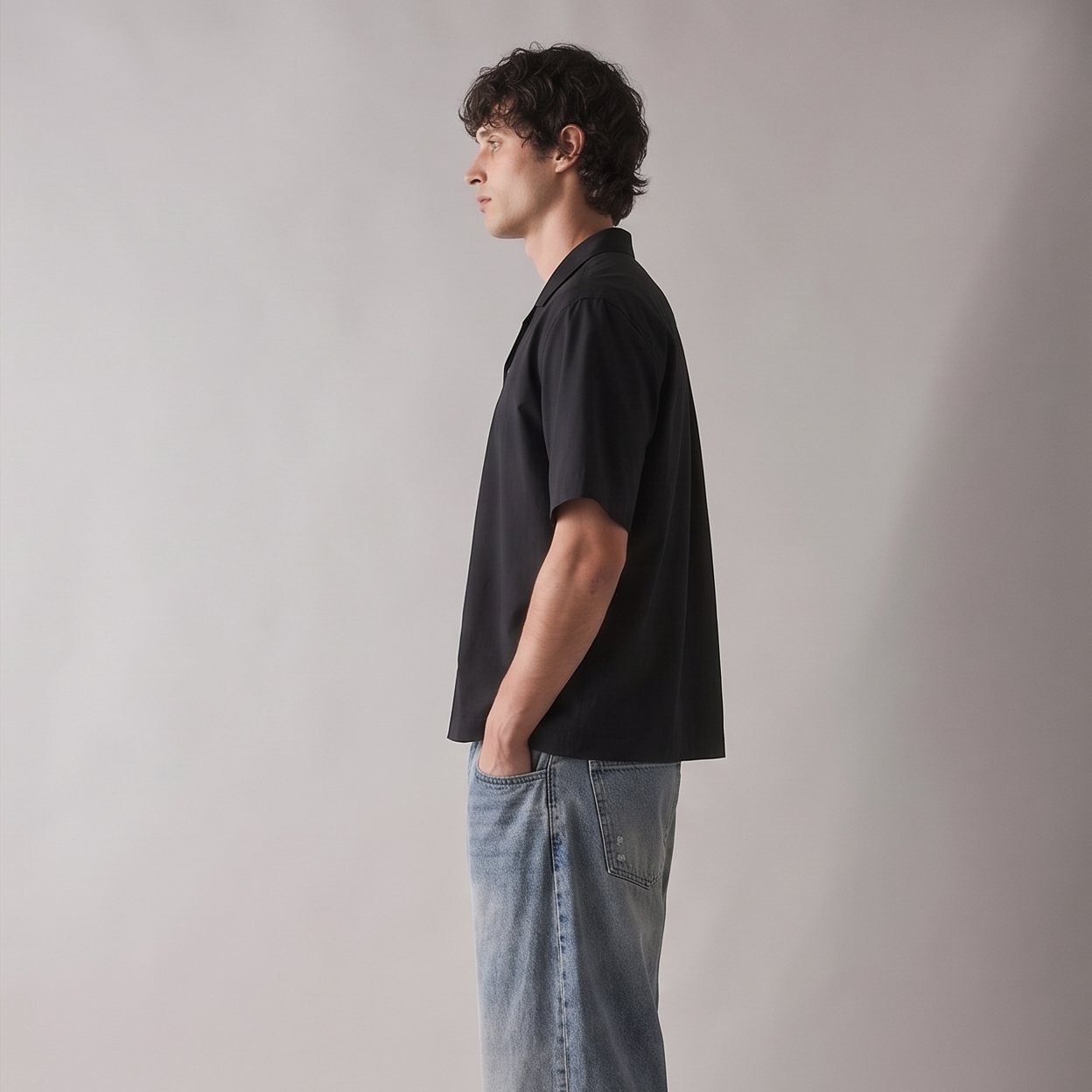 Person wearing a black shirt and blue jeans against a plain background
Side view of ARC Black Boxy Fit Shirt highlighting the oversized boxy silhouette, sleeve structure, and relaxed fit.