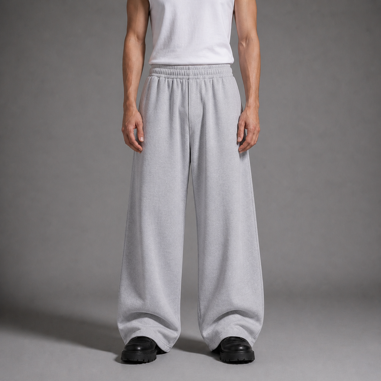 Person wearing light gray wide-leg pants and a white top on a gray 
background
-----------------------------------------
شخص يرتدي بنطالًا واسع الساق باللون الرمادي الفاتح وتوب أبيض على خلفية رمادية.