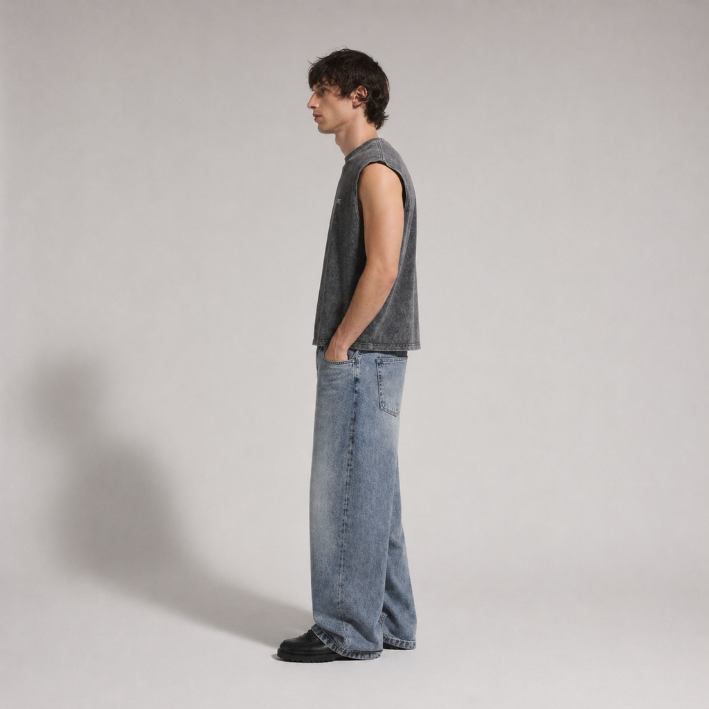 Person wearing a sleeveless shirt and jeans standing against a plain background form ARC