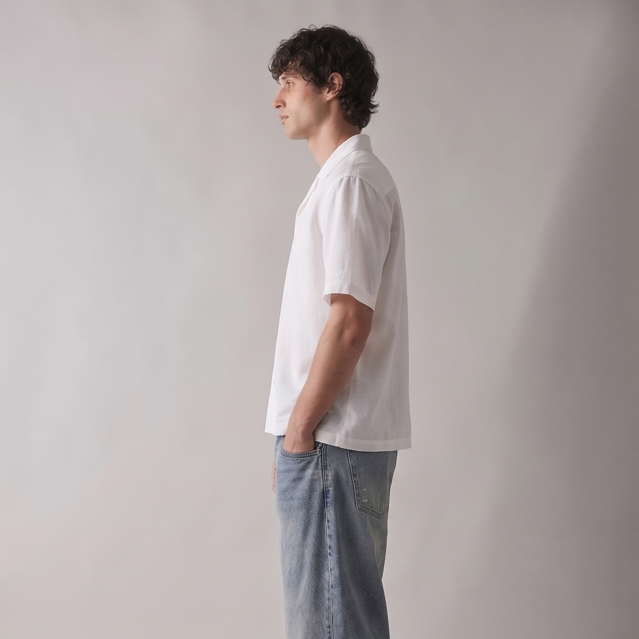 Man wearing a white shirt and light blue jeans against a plain background
Side view of ARC White Boxy Fit Shirt highlighting the relaxed boxy fit, sleeve structure, and contemporary silhouette.